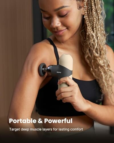 Woman using a massage gun on her arm.